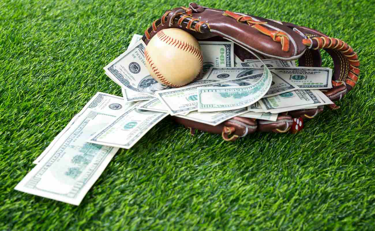 baseball in a glove with dollar bills in concept of getting money with bets in baseball