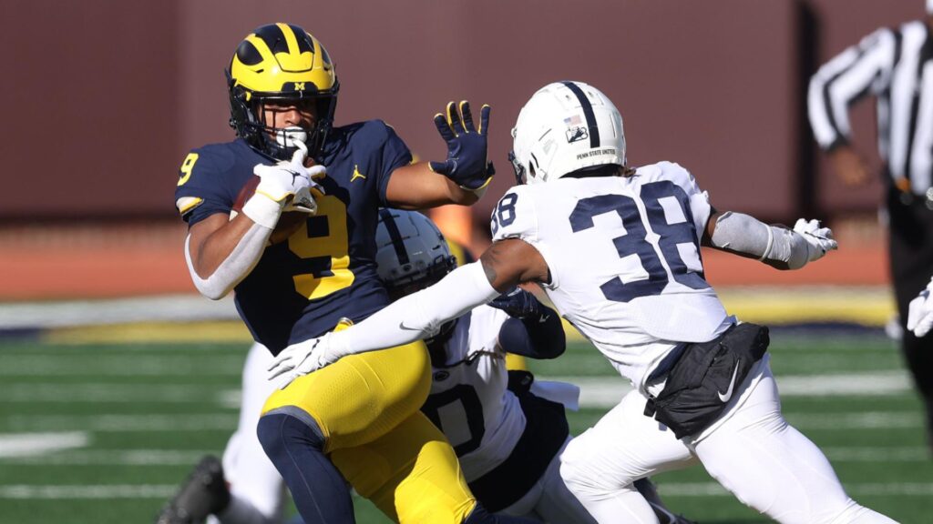 Chris Evans #9 of the Michigan Wolverines tries to get through the tackle of Lamont Wade #38 of the Penn State Nittany Lions during a during the first half run at Michigan Stadium on November 28, 2020 in Ann Arbor, Michigan. (Photo by Gregory Shamus/Getty Images)